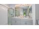 Bathroom features a double sink vanity, a large mirror, and a glass-enclosed shower at 7359 Capstone Dr, Groveland, FL 34736
