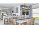 Bright dining area with a modern light fixture, white table, and seating for four, adjacent to the kitchen at 7359 Capstone Dr, Groveland, FL 34736