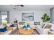 Comfortable living room features a white sectional sofa, a round coffee table, and stylish decor at 7359 Capstone Dr, Groveland, FL 34736