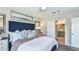Comfortable bedroom with a large blue headboard, complementary pillows, and an ensuite bathroom at 7359 Capstone Dr, Groveland, FL 34736