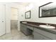 Bathroom featuring dual vanity, stone countertops, neutral tile floors, and updated fixtures at 7536 Fenwick Cove Ln, Orlando, FL 32819