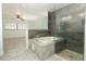 Bathroom featuring a shower with glass door and a soaking tub and bright light at 7536 Fenwick Cove Ln, Orlando, FL 32819