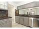 Well-appointed kitchen featuring gray cabinets, stone countertops, and stainless steel appliances, perfect for cooking and entertaining at 7536 Fenwick Cove Ln, Orlando, FL 32819