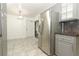 Kitchen featuring stainless steel refrigerator, tile backsplash, and gray cabinetry at 7536 Fenwick Cove Ln, Orlando, FL 32819