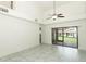 Living room featuring tall ceiling, tile floors, and sliding glass doors with screen at 7536 Fenwick Cove Ln, Orlando, FL 32819