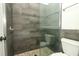 Modern shower with tile walls, glass door, and pebble floor at 7536 Fenwick Cove Ln, Orlando, FL 32819