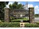 Elegant community entrance sign with stone pillars and manicured landscaping at 7536 Fenwick Cove Ln, Orlando, FL 32819