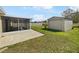 Expansive backyard featuring a screened-in porch and a storage shed at 759 Dromedary Dr, Kissimmee, FL 34759