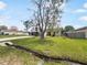 Inviting home exterior featuring a large tree, spacious driveway, and an American flag at 759 Dromedary Dr, Kissimmee, FL 34759