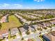 Aerial view showcases planned neighborhood homes next to open field, blending residential with natural spaces at 7916 Wandering Way, Orlando, FL 32836