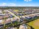 Scenic aerial view featuring neighborhood homes, a community lake, and green spaces under a sunny sky at 7916 Wandering Way, Orlando, FL 32836