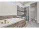 Bathroom featuring a modern soaking tub and a glass-enclosed shower, complemented by sleek fixtures and tile work at 7916 Wandering Way, Orlando, FL 32836