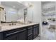 Bathroom features double vanity sinks, elegant lighting, and a view into the bedroom at 7916 Wandering Way, Orlando, FL 32836