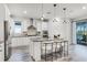 Bright kitchen features stainless steel appliances, white cabinets, island seating, and access to the outdoor patio at 7916 Wandering Way, Orlando, FL 32836
