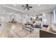 Open-concept living room featuring hardwood floors and ample seating, adjacent to a dining area and kitchen at 7916 Wandering Way, Orlando, FL 32836