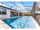 Expansive screened-in pool area with outdoor seating, lounging, and a vibrant orange umbrella at 7916 Wandering Way, Orlando, FL 32836