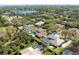 A neighborhood aerial view showcasing a large pool and beautiful surrounding landscaping and a view of a lake at 8661 Crestgate Cir, Orlando, FL 32819