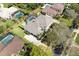 Aerial view of the property featuring the backyard pool, lush landscaping and multiple trees at 8661 Crestgate Cir, Orlando, FL 32819