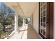 Long balcony with brick floors features several white columns and iron railing at 8661 Crestgate Cir, Orlando, FL 32819