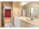 Bathroom with double sinks, mirrors, and an open doorway at 8661 Crestgate Cir, Orlando, FL 32819