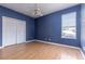 Bedroom showcases a ceiling fan, closet, and a window with wood laminate flooring at 8661 Crestgate Cir, Orlando, FL 32819