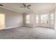 Spacious living room with neutral tones, large windows, and ceiling fan at 8661 Crestgate Cir, Orlando, FL 32819