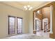 Bright living area featuring arched doorways, a chandelier, and large windows at 8661 Crestgate Cir, Orlando, FL 32819
