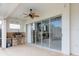 Covered outdoor kitchen with ceiling fan boasts a gas grill and backyard pool view at 8661 Crestgate Cir, Orlando, FL 32819