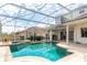 View of a sparkling pool with clear blue water, with a backdrop of outdoor kitchen at 8661 Crestgate Cir, Orlando, FL 32819