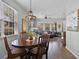 Bright dining area with a wooden table, chandelier, and views of the adjacent living room with a comfortable seating area at 9228 Cardinal Meadow Trl, Orlando, FL 32827