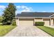Exterior view showcasing the home's attached garage and brick-paved driveway at 9228 Cardinal Meadow Trl, Orlando, FL 32827