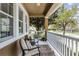 Cozy front porch featuring comfortable seating, decorative rug, white railings, and a view of the manicured community at 9228 Cardinal Meadow Trl, Orlando, FL 32827
