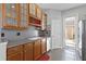 Functional kitchen space with wooden cabinets, display shelving, and an exterior access door for convenience at 9228 Cardinal Meadow Trl, Orlando, FL 32827