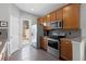 Kitchen featuring stainless steel appliances, wooden cabinets, a door to the outside, and neutral countertops at 9228 Cardinal Meadow Trl, Orlando, FL 32827