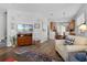Cozy living room featuring hardwood floors, a flat-screen TV, and an open layout with seamless access to the dining area at 9228 Cardinal Meadow Trl, Orlando, FL 32827