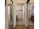 Hallway featuring mirrored closets, leading to a bathroom with double sinks at 9686 Cypress Pine St, Orlando, FL 32827