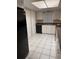 A kitchen with white cabinets, tile floors, and a black refrigerator and dishwasher at 9916 Sweepstakes Ln # 1, Orlando, FL 32837