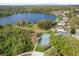 Aerial view featuring a tennis court, lush trees, and waterfront homes on a serene lake at 12018 Radbourne St, Winter Garden, FL 34787