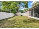 Spacious backyard featuring a white fence, lush green grass, and a charming storage shed at 12018 Radbourne St, Winter Garden, FL 34787