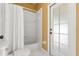 Bright bathroom features a white tiled shower/tub combo and a glass-paneled door at 12018 Radbourne St, Winter Garden, FL 34787