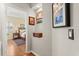 Hallway leading to bedroom with hardwood floors, decorated with framed pictures, and stylish furnishings at 12018 Radbourne St, Winter Garden, FL 34787