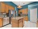 Bright kitchen features stainless steel appliances, a center island with granite countertops and a hanging light fixture at 12018 Radbourne St, Winter Garden, FL 34787