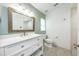 Well-lit bathroom featuring a white vanity with drawers, a large mirror, and a toilet at 127 Thorne Meadow Pass, Davenport, FL 33897