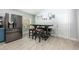 Cozy dining area next to the kitchen with a large refrigerator and a dining table with barstool seating at 127 Thorne Meadow Pass, Davenport, FL 33897