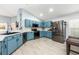 Modern kitchen with blue cabinets, stainless steel appliances, and light countertops for a bright and airy feel at 127 Thorne Meadow Pass, Davenport, FL 33897