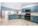 Well-designed kitchen with blue cabinets, stainless steel appliances, and a peninsula with bar seating at 127 Thorne Meadow Pass, Davenport, FL 33897