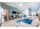 Spacious living room with light blue walls, stylish furnishings, and an open layout with a view of the kitchen at 127 Thorne Meadow Pass, Davenport, FL 33897