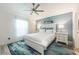 Serene main bedroom with a queen-size bed, blue accent wall, and a ceiling fan, creating a relaxing retreat at 127 Thorne Meadow Pass, Davenport, FL 33897