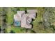 Aerial view of a well-maintained home featuring a screened-in pool, lush landscaping, and a paved driveway at 12848 Jacob Grace Ct, Windermere, FL 34786