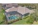 Aerial view of a luxurious home with a screened-in pool and spa, surrounded by a landscaped yard at 12848 Jacob Grace Ct, Windermere, FL 34786